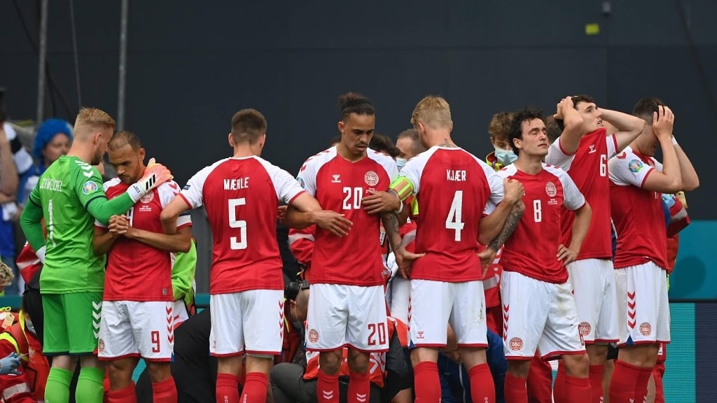 Teamgenoten vormen een cirkel om Eriksen