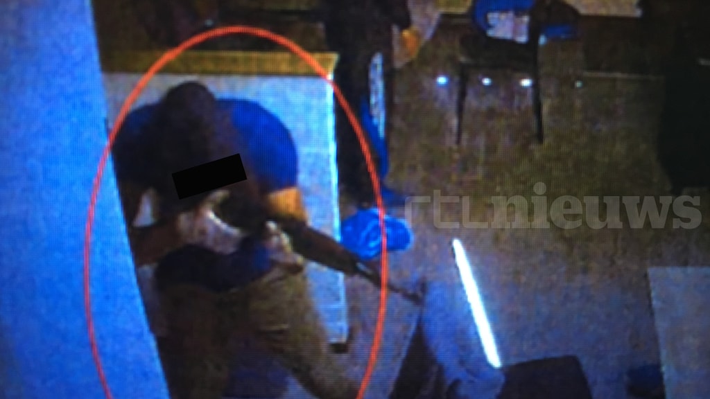 Met zijn AK-47 richt hij op verschillende punten in het vakantiehuisje.