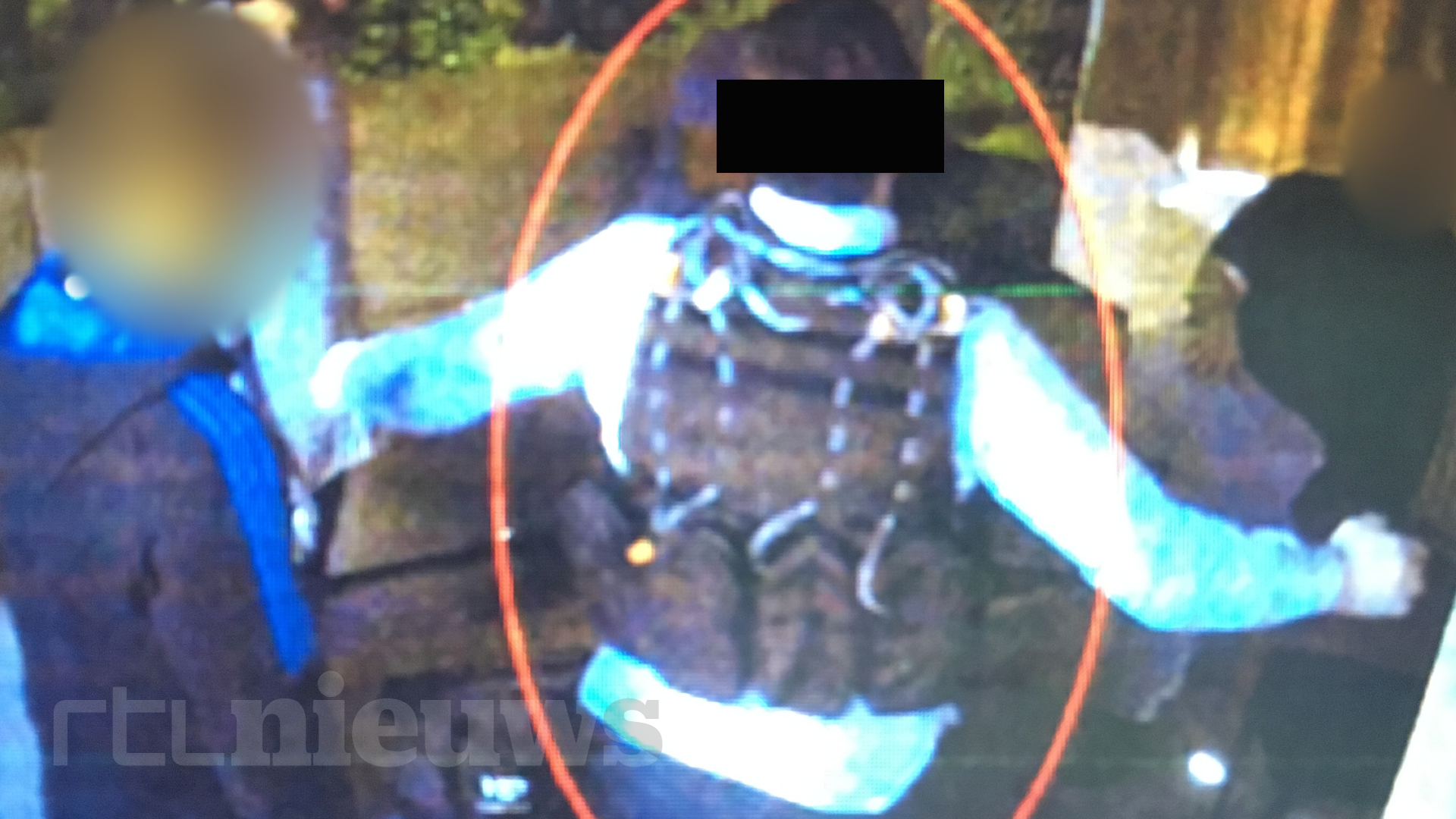 Een van de verdachten draagt een bomvest en spreidt zijn armen.