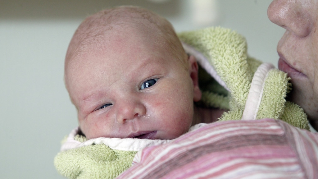 Een kraamverzorger droogt een baby af