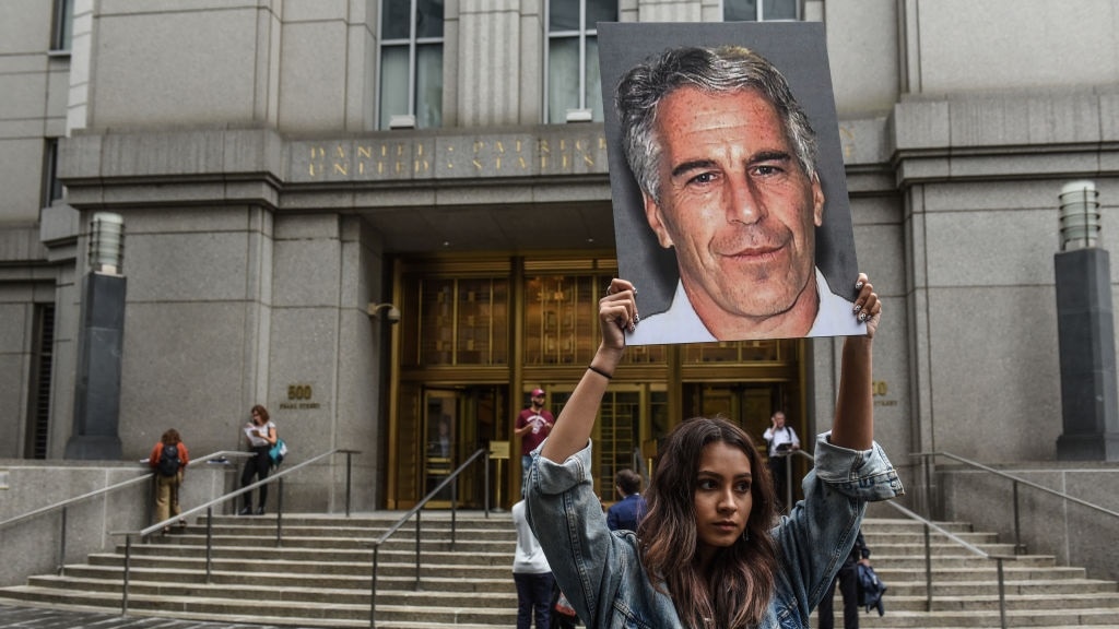 Een vrouw bij de rechtbank met een foto van Jeffrey Epstein.
