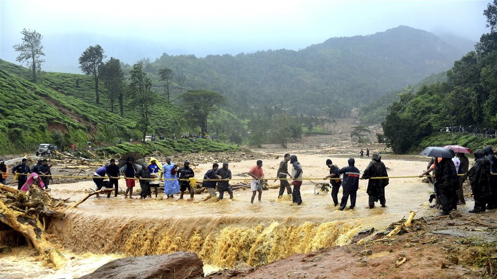Inwoners van Kerala op weg naar hogergelegen gebied tijdens een overstroming.