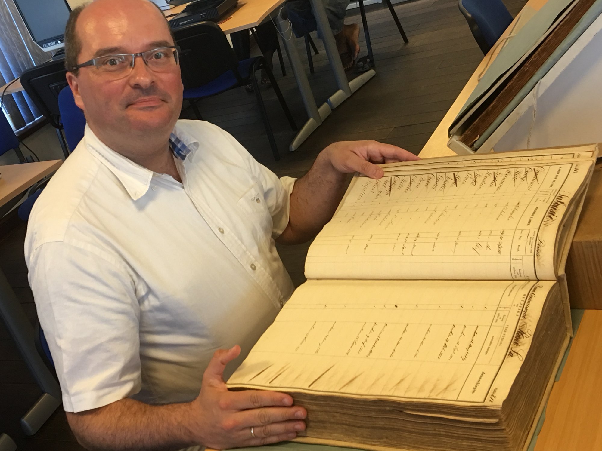 Onderzoeker Coen van Galen met de papieren registers. 