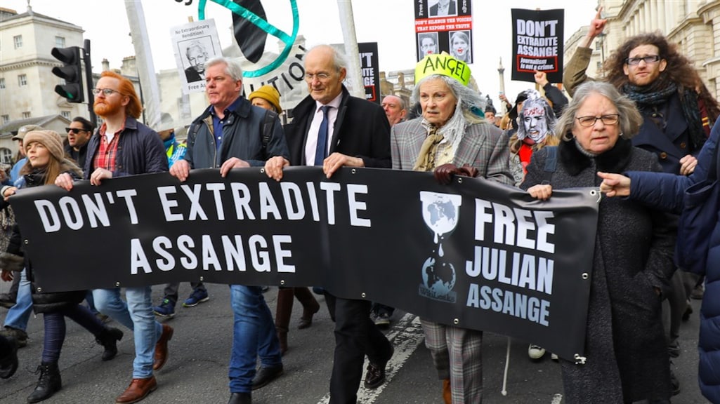 Protestmars in Londen met als vierde van links de vader van Assange