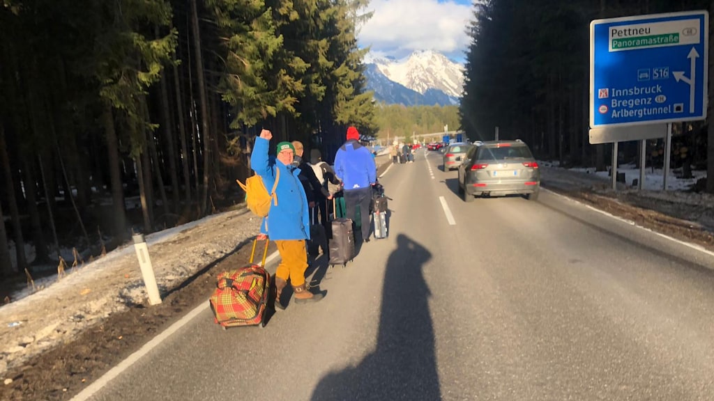 Edgar en zijn gezelschap loopt over de weg, op zoek naar een lift.