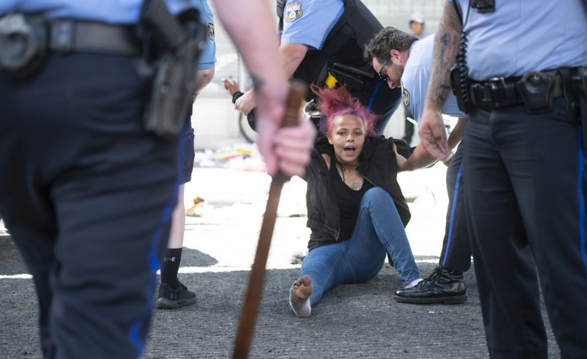 Politieagenten slepen een demonstrant weg tijdens rellen in Philadelphia