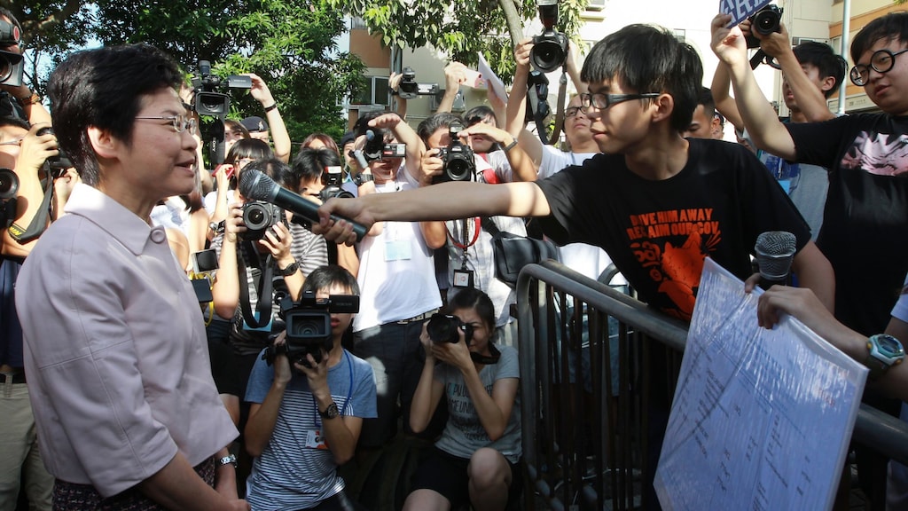Joshua Wong zoekt in 2014 de confrontatie op met politica Carrie Lam (links). Jarenlang blijven ze tegenover elkaar staan. Wong als aanvoerder van de protestbeweging voor meer democratie en Carrie Lam als hoogste leider van Hongkong.