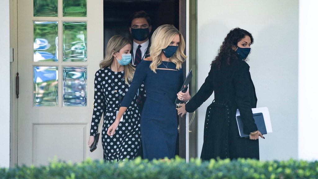 Stafleden van het Witte Huis, met als tweede van rechts woordvoerder Kayleigh McEnany, lopen rond met mondkapjes op.
