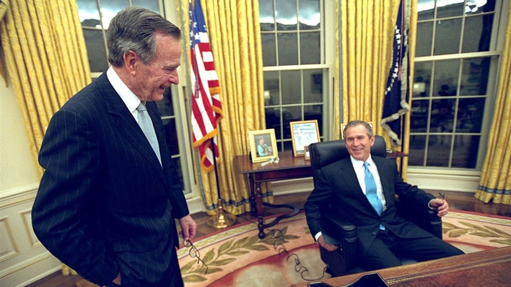 George W. Bush neemt in het bijzijn van zijn vader op de eerste dag plaats in het Oval Office.