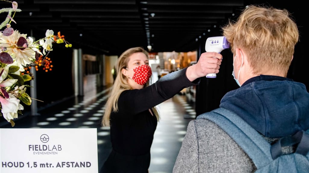 De temperatuur van een bezoeker wordt gemeten.