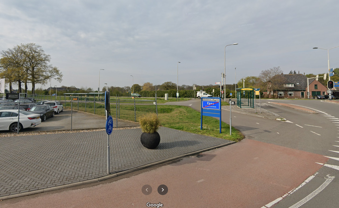 Vanuit de woonboerderij in Epse kijk je uit op een druk kruispunt en een stuk grond waar auto's te koop staan.