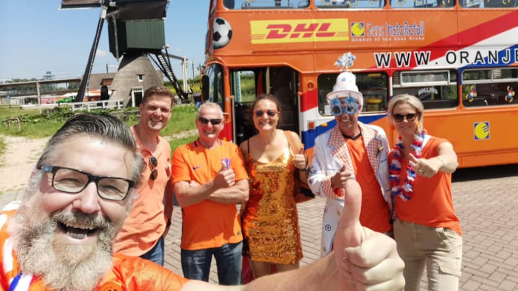 Henk (links) met zijn maatjes voor de beroemde Oranjebus