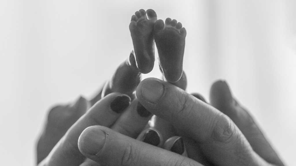 Handen van Renate en Ilyas met Elijah. Foto: Chantal van Riemsdijk