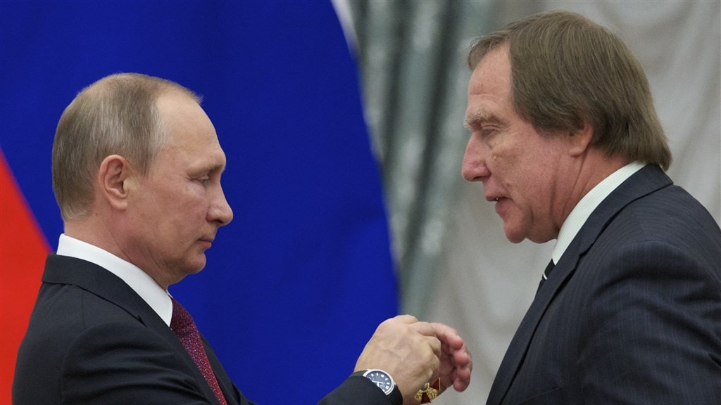 Roldugin (r) krijgt een medaille opgespeld door Vladimir Poetin in 2016.