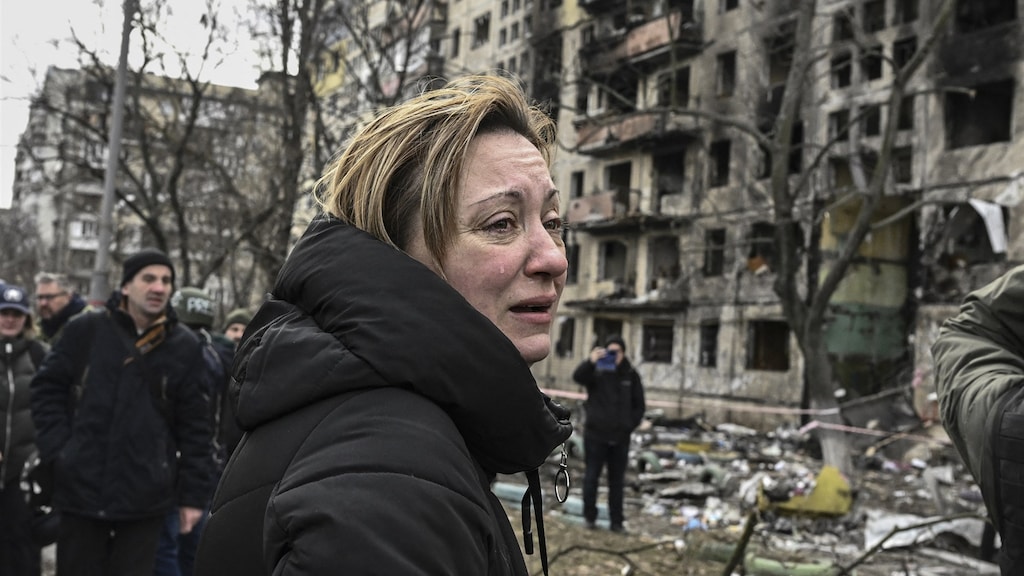 Een vrouw bij de verwoeste flatgebouwen in het noordwestelijke Obolon-district van Kiev.