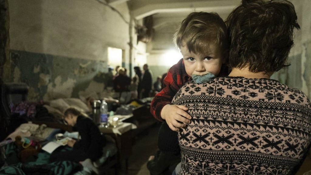 Een vrouw en een kind in een geïmproviseerde schuilkelder in Marioepol.