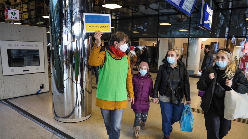 Vrijwilligers vangen Oekraiense vluchtelingen op die aankomen op station Amsterdam Centraal