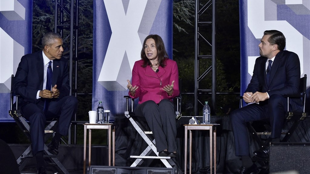 Katharine Hayhoe op het podium samen met Barack Obama en Leonardo DiCaprio.