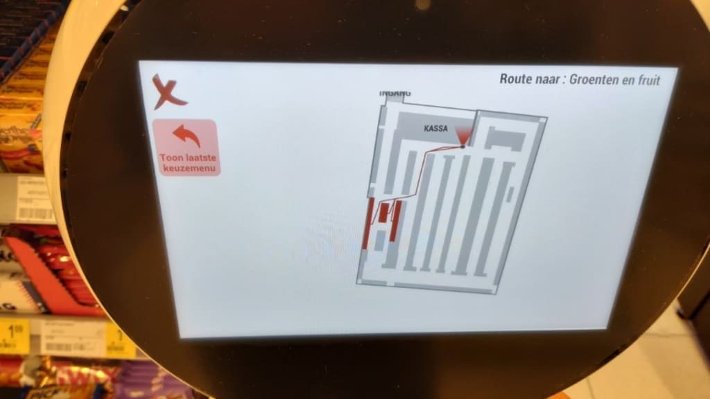 Het scherm van robot Robbie wijst je de weg naar de afdeling groente en fruit.