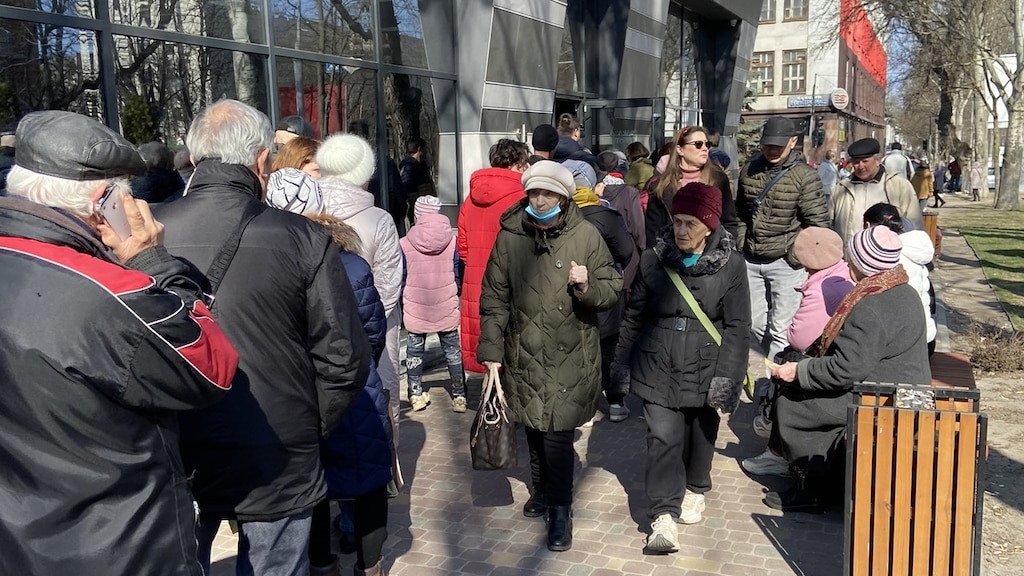 Mensen in de rij bij de winkel.