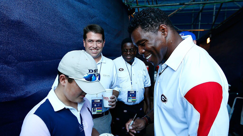 De football-held die politicus werd mag graag handtekeningen uitdelen.