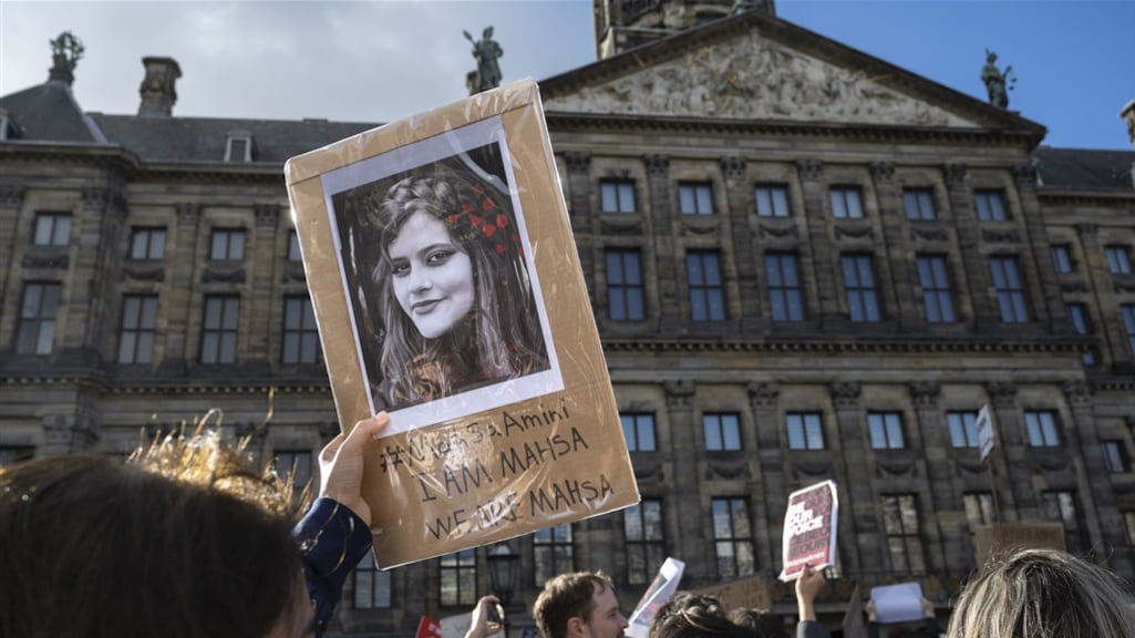 Een afbeelding van Mahsa Jina Amini tijdens een protest op de Dam. De dood van deze jonge vrouw is de aanleiding voor de protesten.
