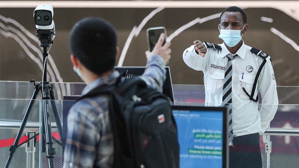 Functionaris checkt Ehteraz-app bij bezoeker in Qatar.