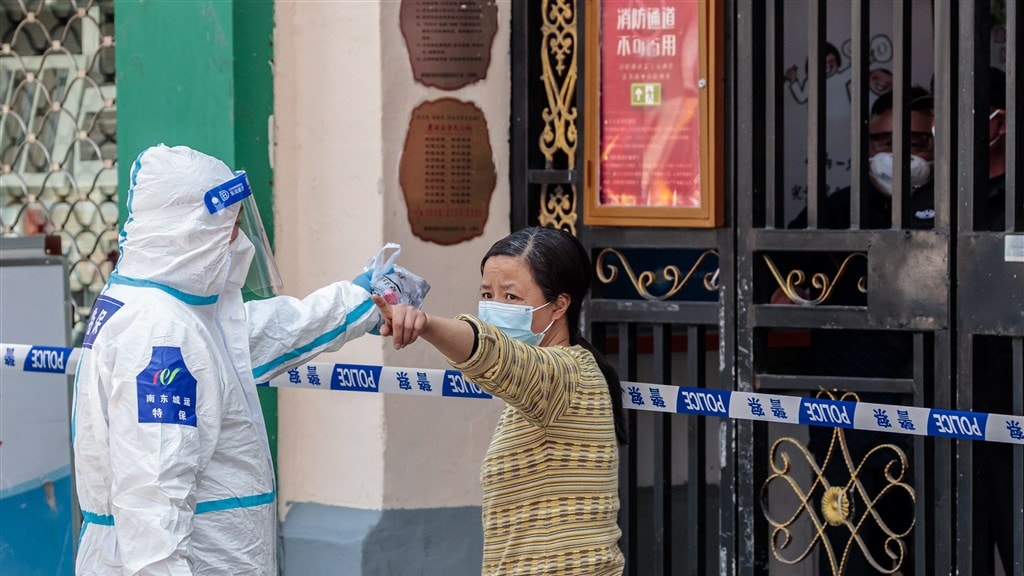 Een dabai stuurt een vrouw terug haar huis in, foto uit maart gemaakt in Shanghai.