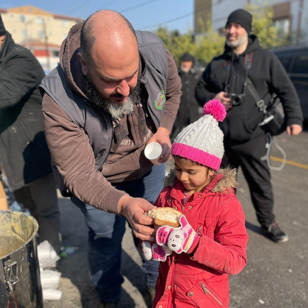 Een klein meisje krijgt voedsel van hulpverleners.