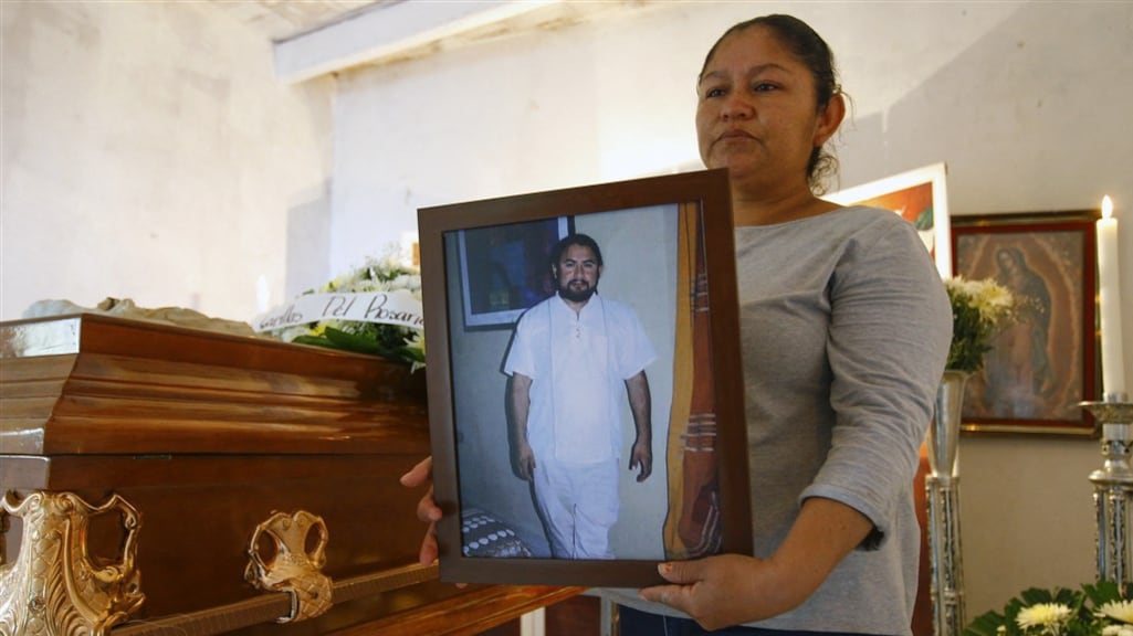 De zus van Ernesto Mendez houdt een foto van haar vermoorde broer vast.