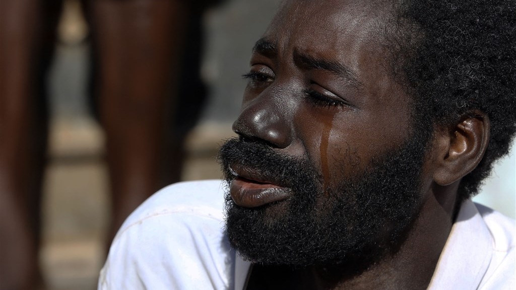 Een huilende man uit Mali in een safe house in Bani Walid (Libië).