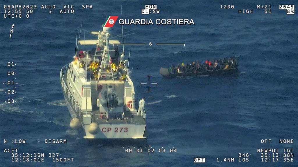 De Italiaanse kustwacht redt een klein bootje met migranten.