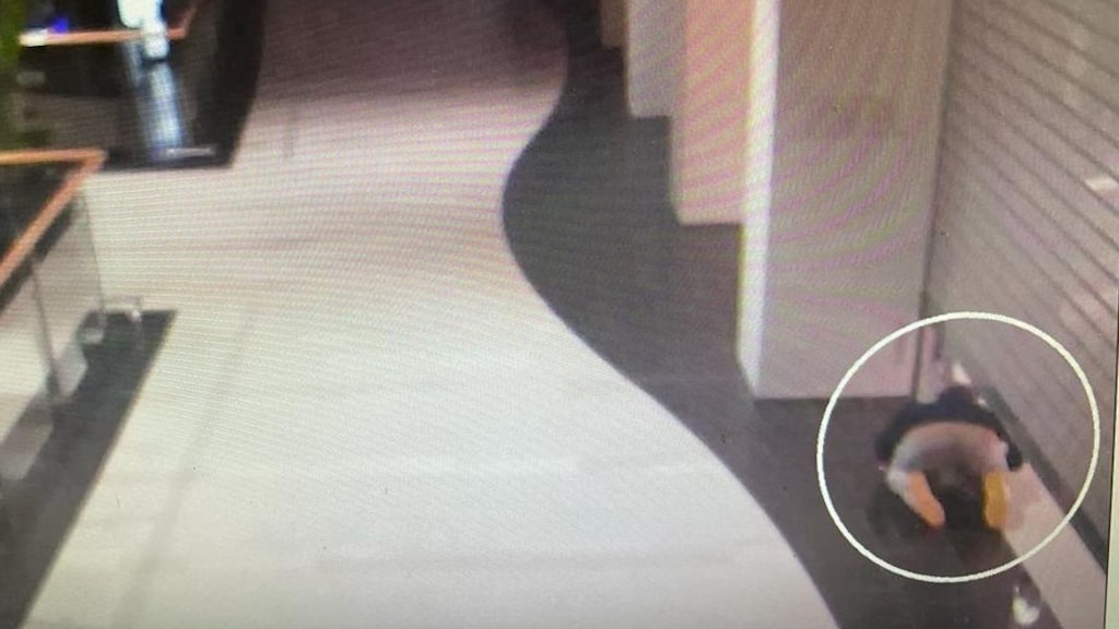 Hier probeert de 22-jarige onder de luiken van een winkel te kruipen.