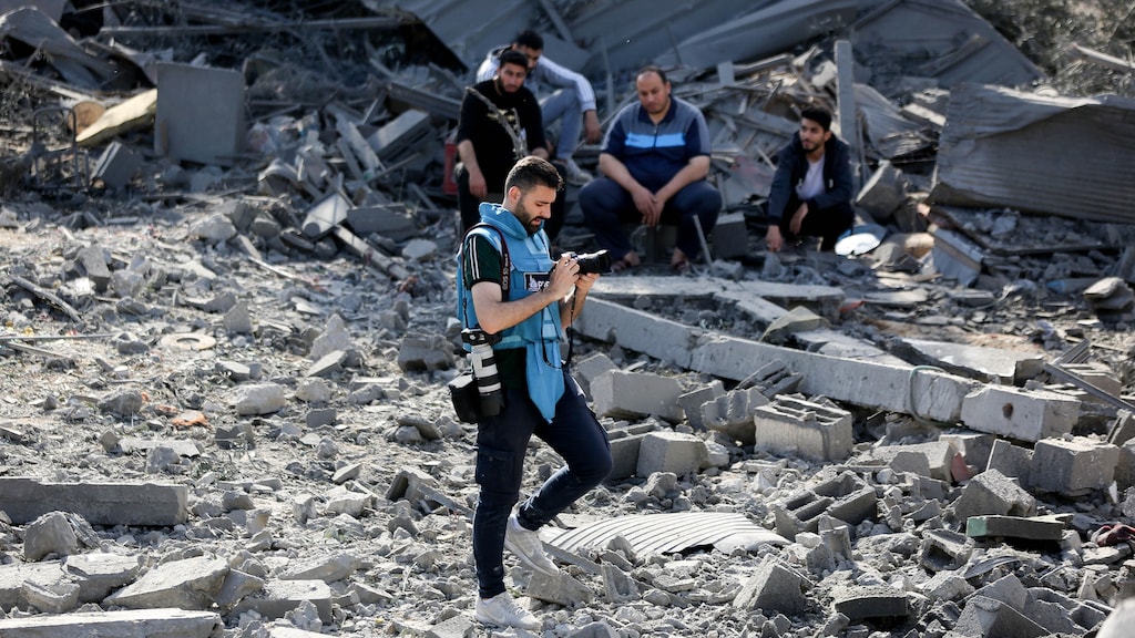 Een journalist doet verslag van de schade aan Palestijnse huizen na Israëlische luchtaanvallen in de Gazastrook.