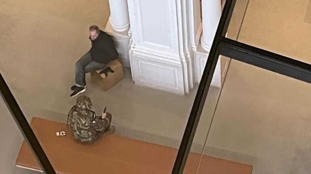 De dader samen met een gegijzelde man.