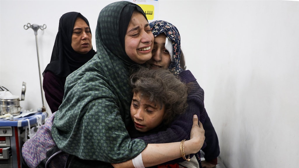Emotie bij een Palestijnse vrouw wanneer ze familieleden een knuffel geeft in een ziekenhuis in Rafah.