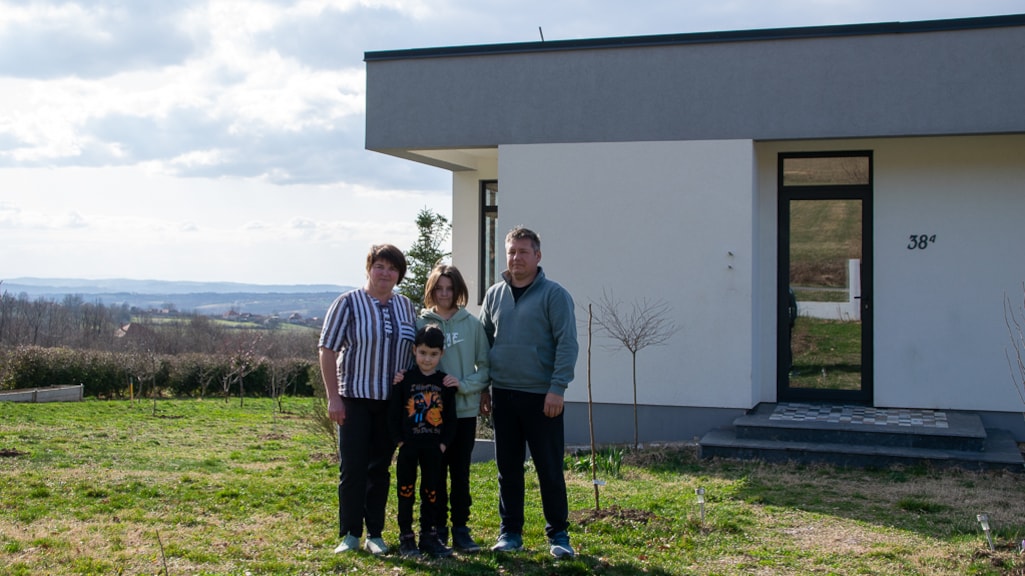 Elena Koposova met haar gezin voor het gerenoveerde huis in Servië.