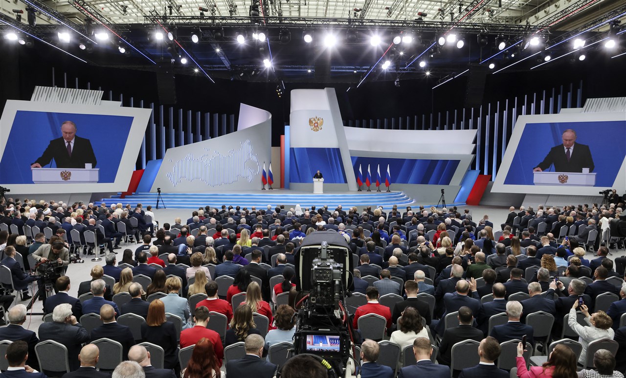 Poetin spreekt een volle zaal toe.