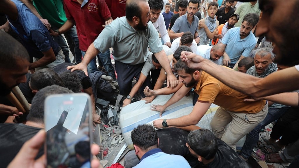 Palestijnen redden een overlevende na een bombardement in Gaza.