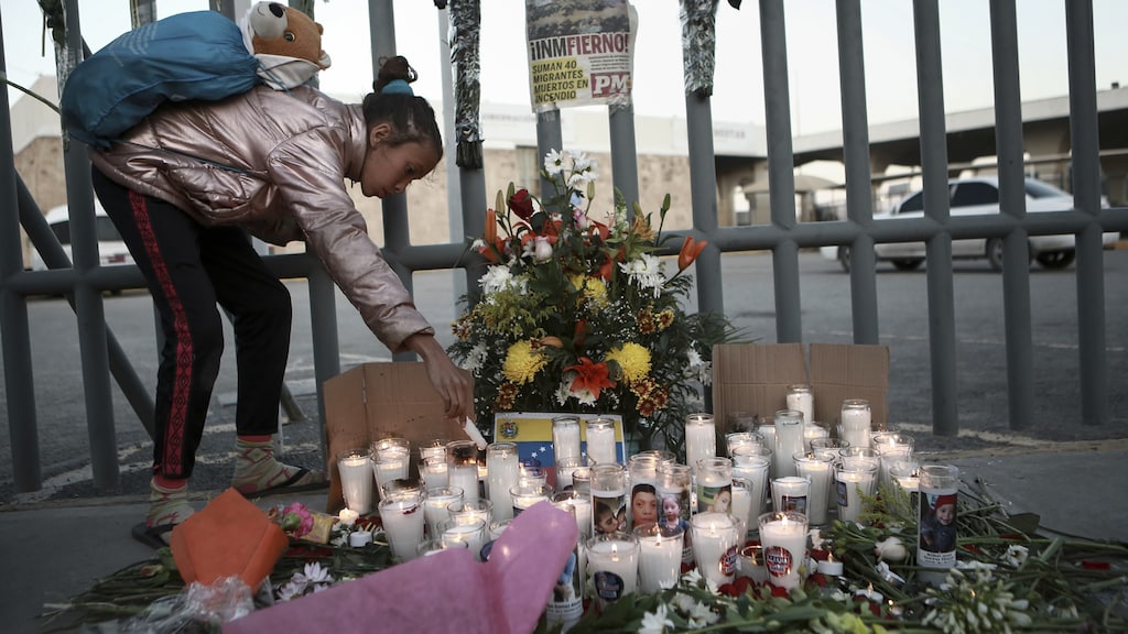 Een vrouw legt bloemen na de brand in het detentiecentrum.