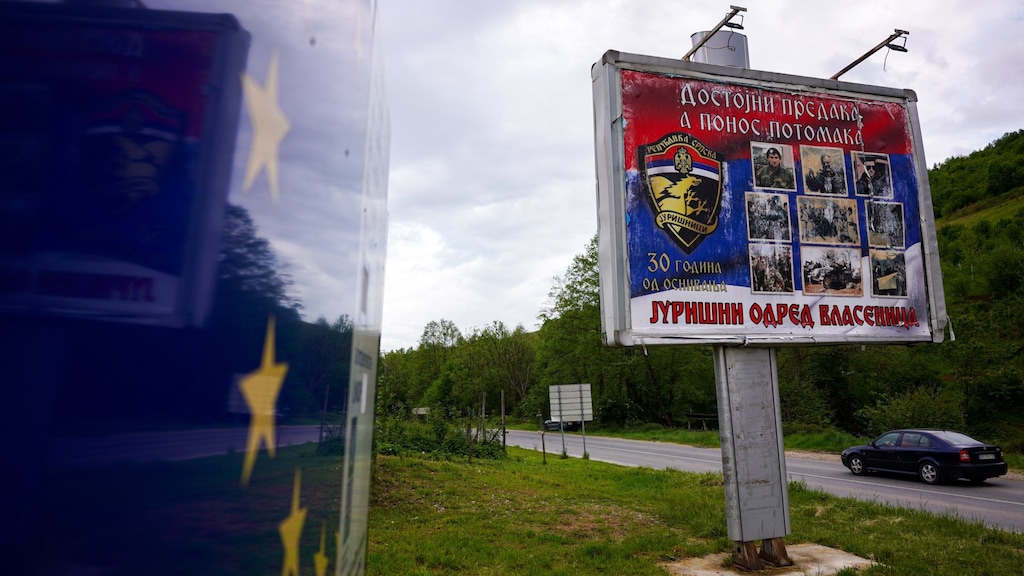 Een banner langs de weg met daarop de 'helden' van Republika Srpska, met onder andere een foto van Ratko Mladic, die door het Joegoslaviëtribunaal veroordeeld is voor genocide en zijn levenslange straf uitzit in een cel in Den Haag.