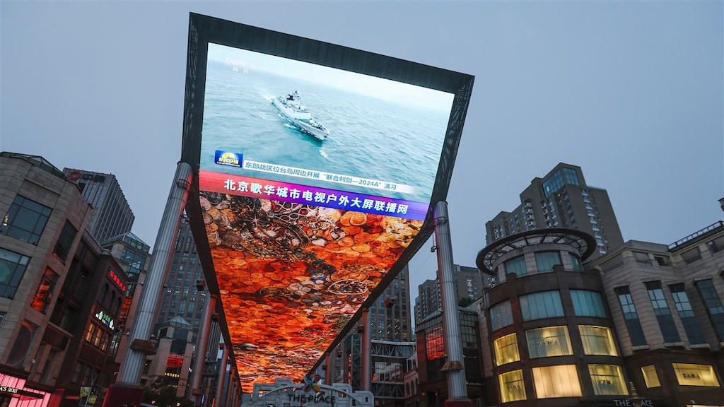 In Beijing zendt een groot scherm het nieuws uit dat China oefeningen uitvoert rond Taiwan.