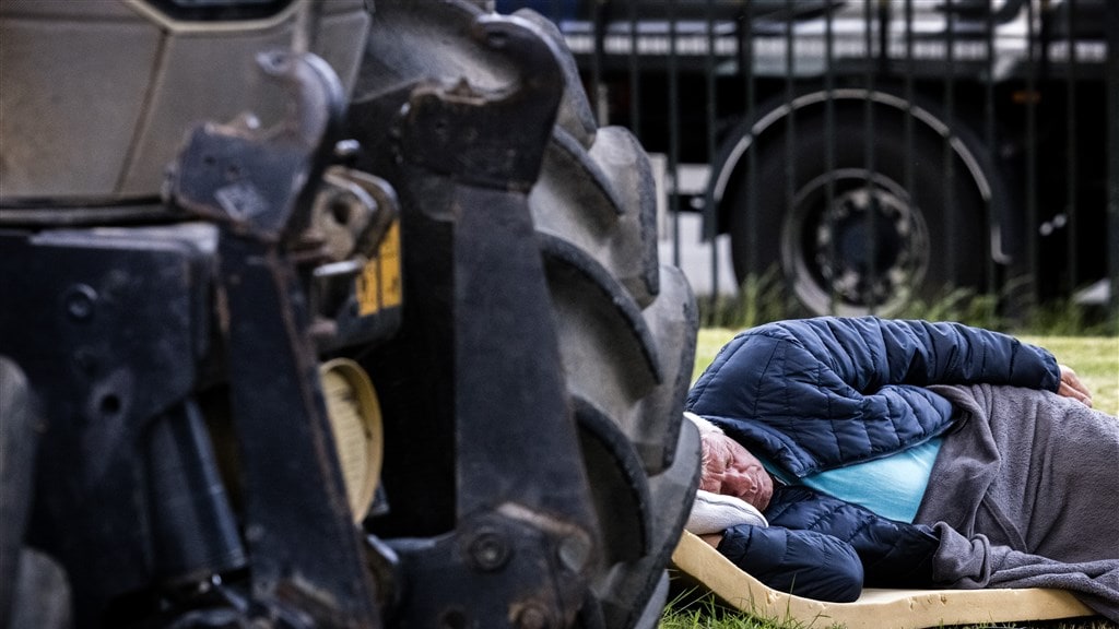 Een Duitse boer rust uit bij zijn tractor in Someren. Vandaaruit trekken naar Brussel.