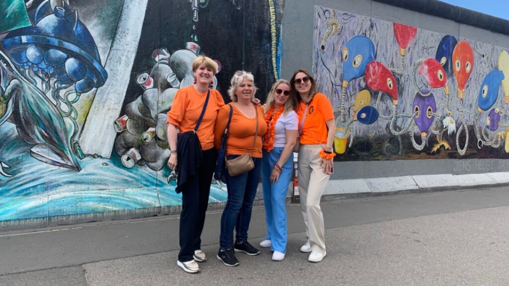 Yvonne, Matty, Chantal en Niké voor een schildering op de Berlijnse Muur.