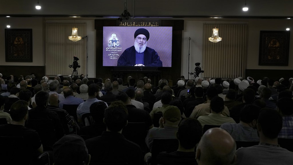 Hezbollah-aanhangers kijken op een scherm naar een toespraak van Hezbollah-leider Sayyed Hassan Nasrallah.