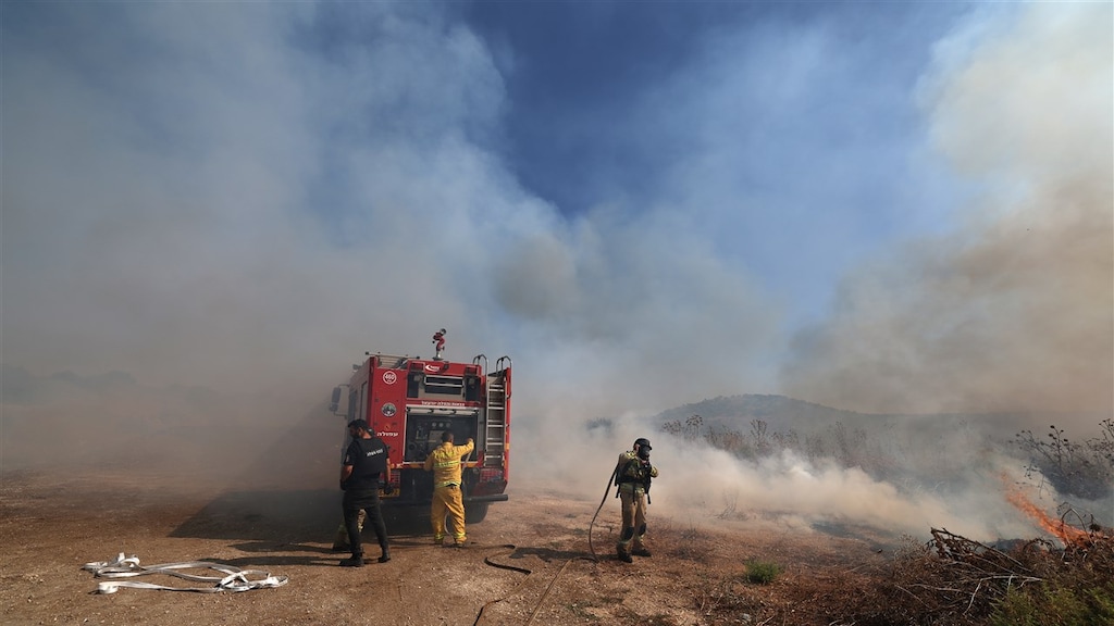 Brandweerlieden blussen een brand nadat Israëlische troepen een luchtdoel onderschepten dat vanuit Libanon overstak