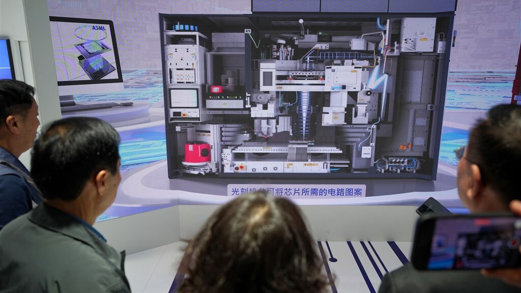 Bezoekers aan een Chinese techbeurs bekijken ASML-technologie.