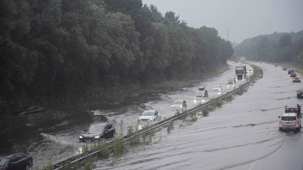 Extreme regenval zorgt voor ondergelopen A1 bij De Lutte, auto's vast in het water