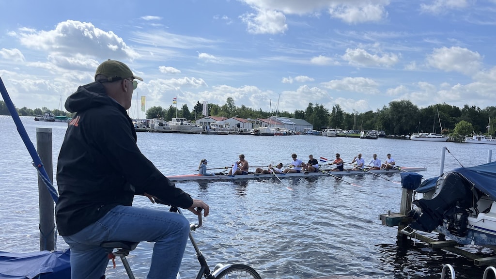 Coach Diederik Simon geeft aan de oever aanwijzingen aan de Holland Acht.