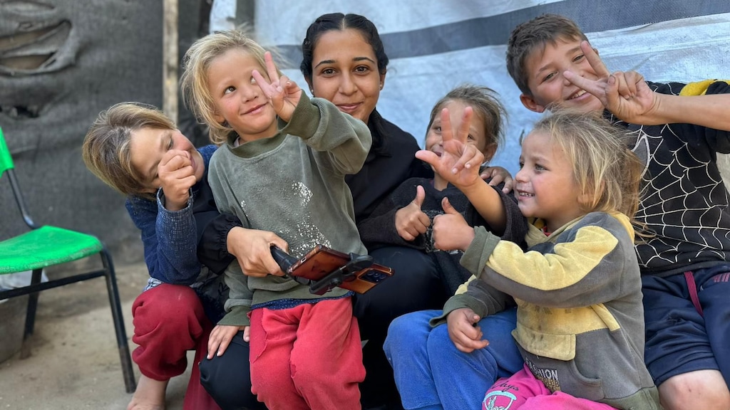 Qamar (tweede van links met een grijze trui) en haar zusje (rechts in de trui met geel) in het kamp.
